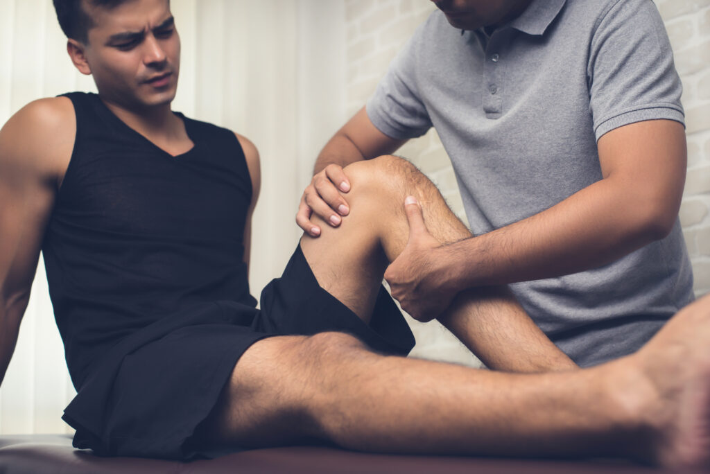 A physiotherapist performs manual treatment on a mans knee